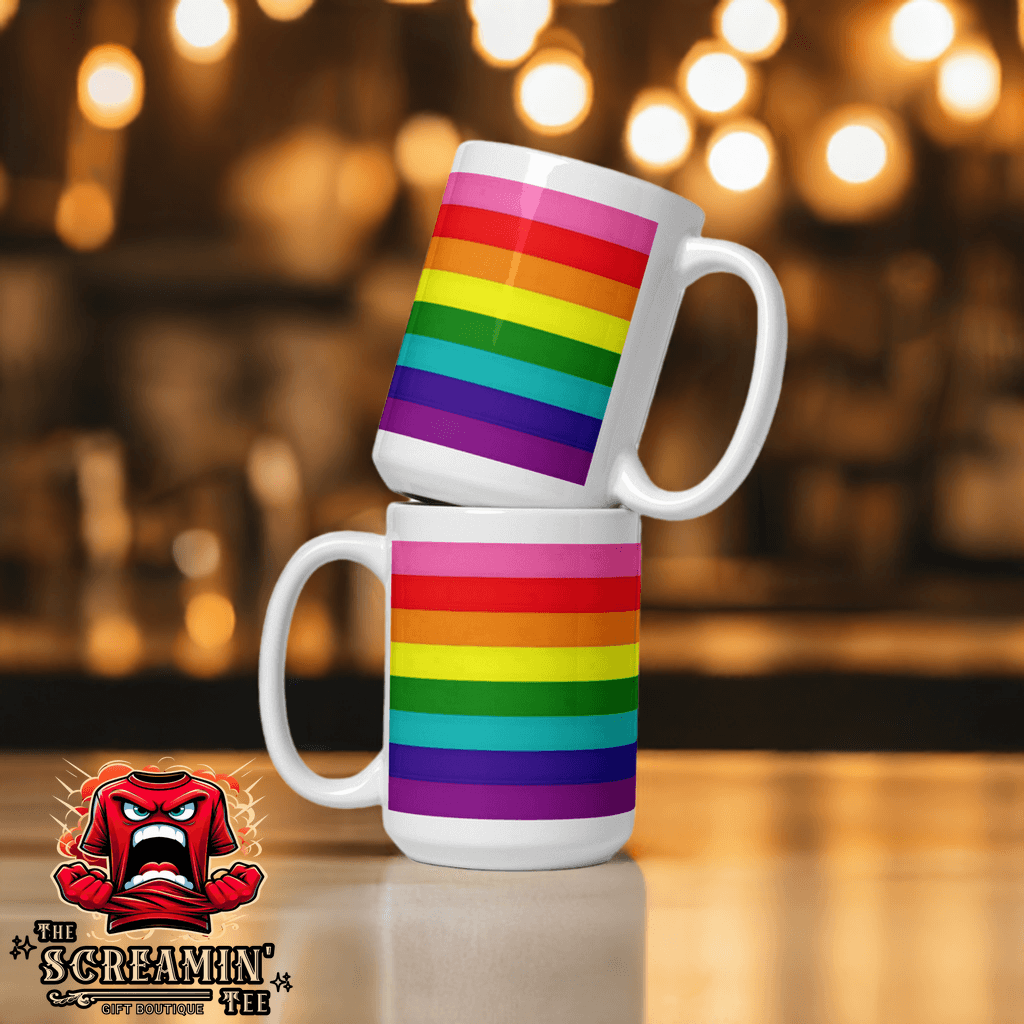 Two Gilbert Baker Pride Mugs stacked, featuring vibrant rainbow stripes against a blurred background.