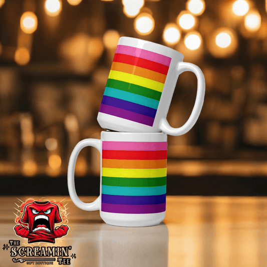 Two Gilbert Baker Pride Mugs stacked, featuring vibrant rainbow stripes against a blurred background.