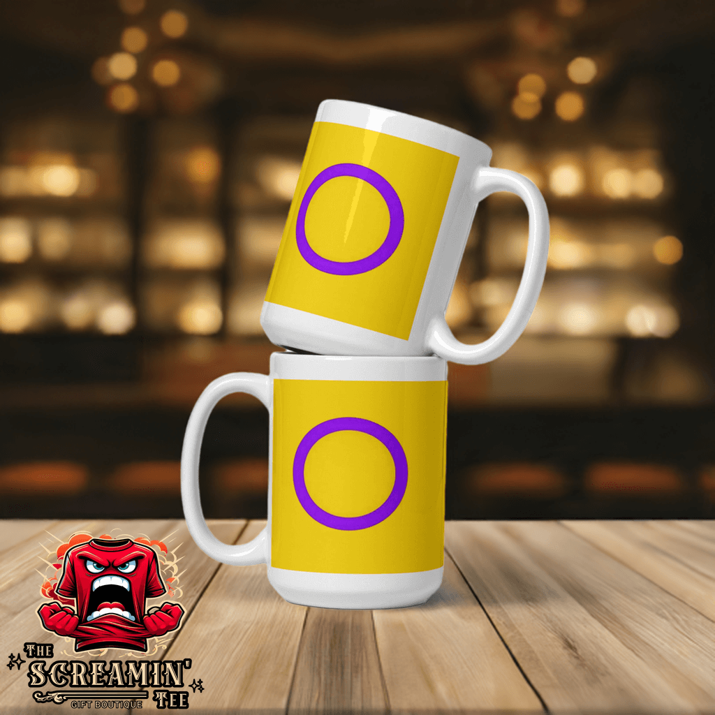 Intersex Pride Mug featuring a vibrant yellow design with a purple circle, displayed on a wooden table.